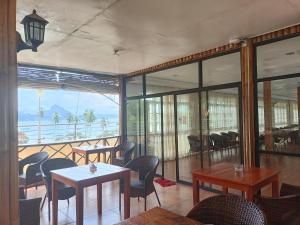 a restaurant with tables and chairs and a balcony at One El Nido Suite in El Nido