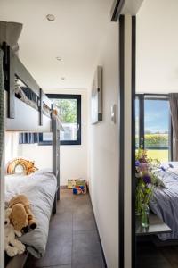 1 dormitorio con 2 camas individuales y ventana grande en Luxus Cube Meerblick Veluwemeer am Strand in erster Reihe, en Hulshorst