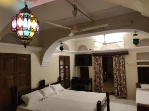 a bedroom with a bed and a chandelier at Natraj Guest House in Ajmer