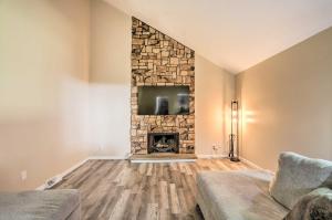 a living room with a stone fireplace and a tv at Cozy Duplex Close to Toledo Botanical Garden in Toledo