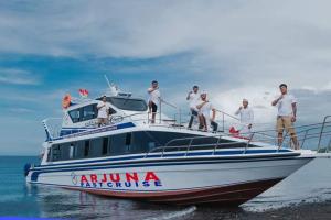 un grupo de hombres parados en un barco en el agua en Anugerah Villas, en Amed