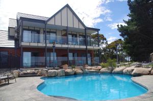 a house with a swimming pool in front of a building at The View on Grossmans in Torquay