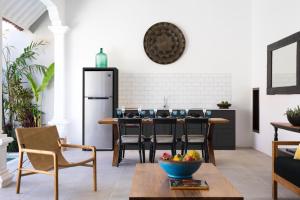 a kitchen with a table with chairs and a refrigerator at Villa Toru - Stylish luxury in Legian, tranquil location, walk to beach in Legian +22 photos