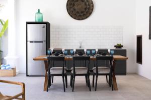 kuchnia ze stołem z krzesłami i lodówką w obiekcie Villa Toru - Stylish luxury in Legian, tranquil location, walk to beach w mieście Legian