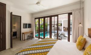 een slaapkamer met een bed en uitzicht op een zwembad bij Villa Toru - Stylish luxury in Legian, tranquil location, walk to beach in Legian