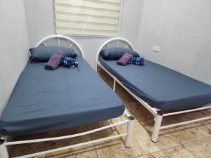 2 camas en una habitación con almohadas en MK Homestay, en Butterworth