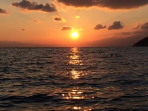 a sunset over the ocean with the sun setting at Villa Platanaki in Kerveli