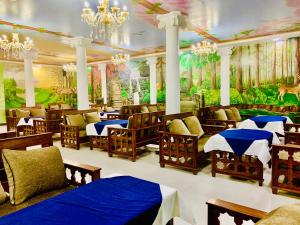 a restaurant with tables and chairs and a mural at Dream Palace Resort in Kathmandu