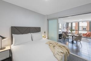 ブリスベンにあるMeriton Suites Adelaide Street, Brisbaneのベッドルーム1室(ベッド1台付)、リビングルームが備わります。