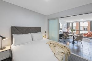 a bedroom with a bed and a living room at Meriton Suites Adelaide Street, Brisbane in Brisbane