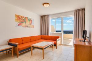 a living room with a couch and a view of the ocean at Apartments Palm Garden in Morro del Jable