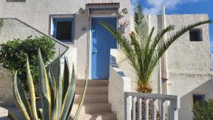 a blue door on a house with palm trees at Step into a world of nature One Room Private Suite shared pool in Hersonissos +3 photos