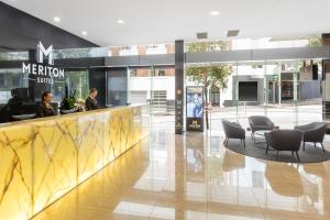 a lobby with chairs and a counter in a building at Meriton Suites Adelaide Street, Brisbane in Brisbane