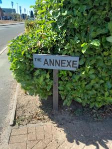 Ein Schild, auf dem steht, dass der Eingang vor einem Busch ist. in der Unterkunft The Annexe, Cornfields in Elmswell