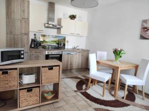 a kitchen with a wooden table and white chairs at Appartement Ferienhaus Sonnenhain in Sollenau