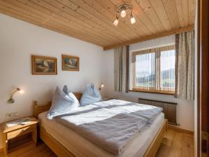 a bedroom with a large bed with a wooden ceiling at Haus Dorfblick in Ellmau