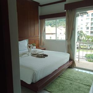 a bedroom with a large bed with a window at New Forest Patong in Patong Beach
