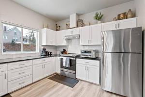 a kitchen with white cabinets and a stainless steel refrigerator at Full ADA Unit - 2 Bed 2 Bath Unit Near Downtown in Spokane