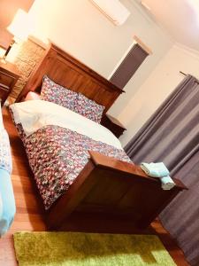 a bedroom with a bed with a wooden headboard at D R Accommodation and Cozy Cabins, Hamilton East near to CBD and Waikato Hospital in Hamilton