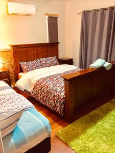 a bedroom with two beds and a green rug at D R Accommodation and Cozy Cabins, Hamilton East near to CBD and Waikato Hospital in Hamilton