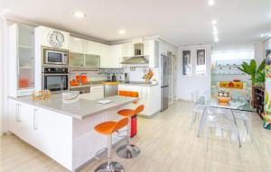 eine Küche mit weißen Schränken und eine Insel mit Barhockern in der Unterkunft 2 Bedroom Cozy Apartment In guilas in Águilas