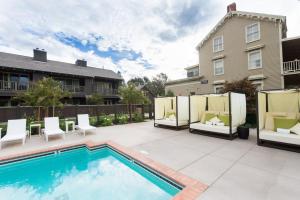 a patio with a pool and chairs and a building at SENZA Hotel in Napa