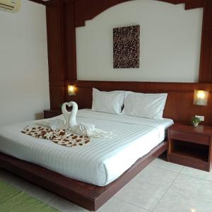 a bedroom with a bed with swans on it at New Forest Patong in Patong Beach