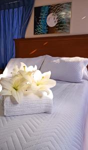 a bunch of white flowers sitting on top of a bed at Elegance Hotel in La Paz