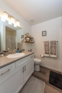 La salle de bains est pourvue d'un lavabo, de toilettes et d'un miroir. dans l'établissement Modern Decor & Style KING bed Wifi with Garage, à Spokane