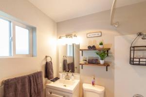 a bathroom with a sink and a toilet and a mirror at Comfortable Duplex Unit - Beautiful Lake Views! in Valley