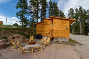 a small wooden cabin with chairs and a bench at Comfortable Duplex Unit - Beautiful Lake Views! in Valley