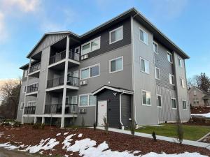 a large apartment building with a garage at Spacious NEW 2 bed 2 bath apt by Downtown Spokane in Spokane