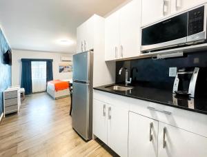 a kitchen with white cabinets and a stainless steel refrigerator at Casa Pellegrino Boutique Hotel in Hollywood