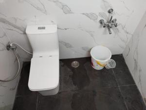 y baño con aseo, lavamanos y cubo. en Tirunelveli Home Stay, en Tirunelveli