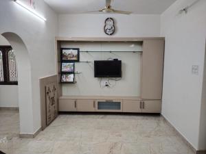 sala de estar con TV de pantalla plana en la pared en Tirunelveli Home Stay, en Tirunelveli