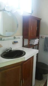 baño con lavabo negro y espejo en Edificio El Constructor Apartamento Independiente, en Guayaquil