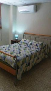 1 dormitorio con 1 cama con edredón azul y blanco en Edificio El Constructor Apartamento Independiente, en Guayaquil