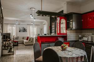 a kitchen with red cabinets and a table in a room at Villa Hermes in Potamós