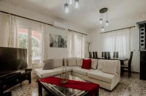 een woonkamer met een witte bank en een tafel bij Villa Hermes in Potamós