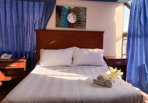 1 dormitorio con 1 cama con toallas en Elegance Hotel en La Paz