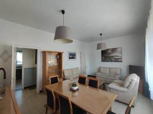 a living room with a wooden table and a dining room at Le Cottage Malouin in Dunkerque