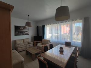 a living room with a table and a couch at Le Cottage Malouin in Dunkerque