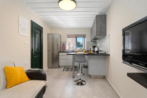 a kitchen with a couch and a table in a room at Ileana-Marina studio 1 in Benitses
