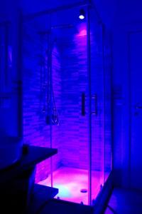 baño con ducha de cristal con luces moradas en Casa Al Porto, en Palermo