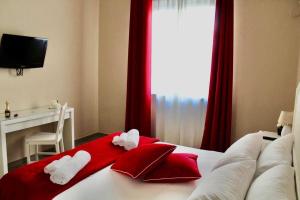 ein Hotelzimmer mit einem Bett mit roten und weißen Kissen in der Unterkunft Casa Al Porto in Palermo