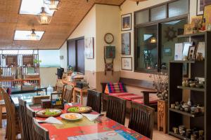 jadalnia ze stołami, krzesłami i zegarem w obiekcie Gita's House w mieście Chiang Rai