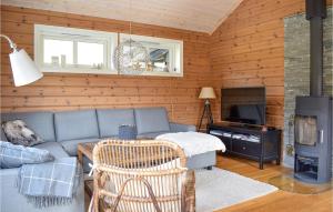 a living room with a blue couch and a fireplace at Beautiful Home In Jsenfjorden With Wifi And 6 Bedrooms in Gullingen