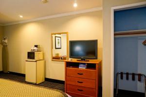 a hotel room with a television on a dresser at Hotel Parmani Near Stanford University in Palo Alto +22 photos