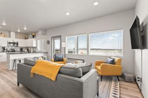 a living room with a gray couch and yellow chairs at New 2 Bed 2 Bath Near Perry Dist and Downtown in Spokane