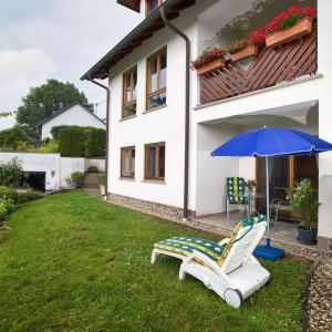 un par de sillas y un paraguas en un patio en Ferienwohnung Meisbüsch, en Merzig
